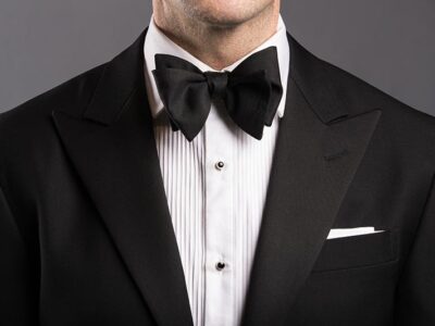 Man wearing a black bow tie with a tuxedo at a formal event