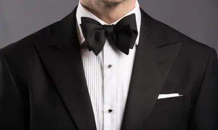 Man wearing a black bow tie with a tuxedo at a formal event
