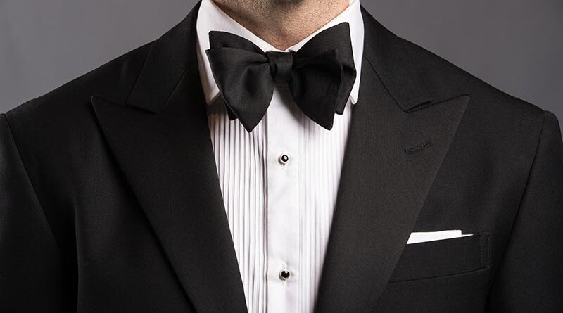 Man wearing a black bow tie with a tuxedo at a formal event