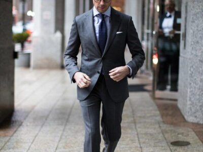 Man in a charcoal grey suit walking on the street
