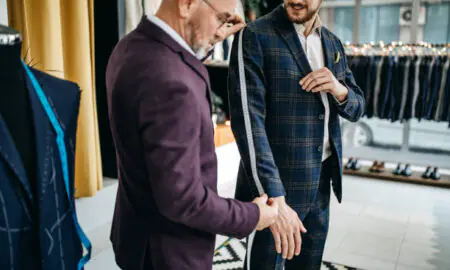 Tailor measuring a man for a suit jacket fitting