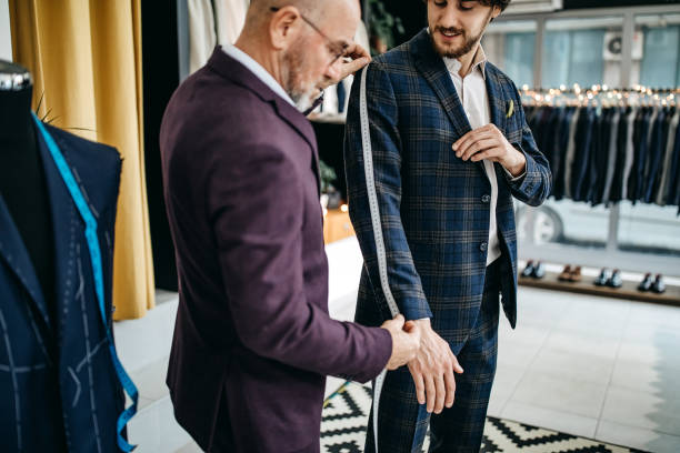 Tailor measuring a man for a suit jacket fitting