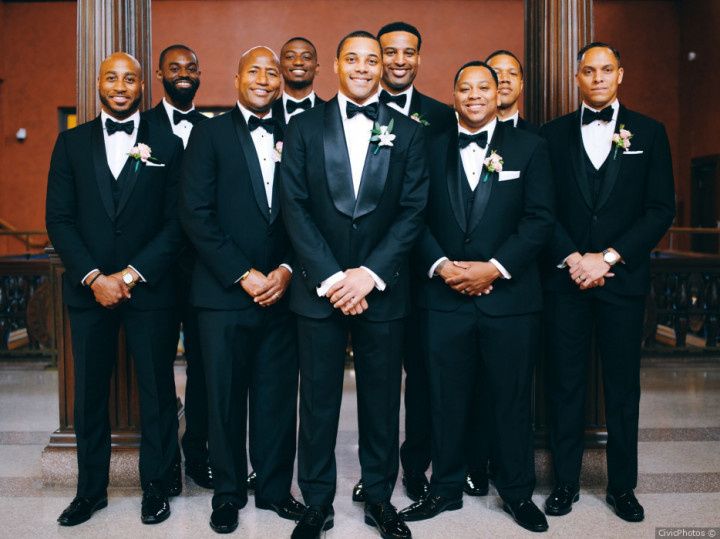 Groomsmen in black tuxedos at a formal wedding